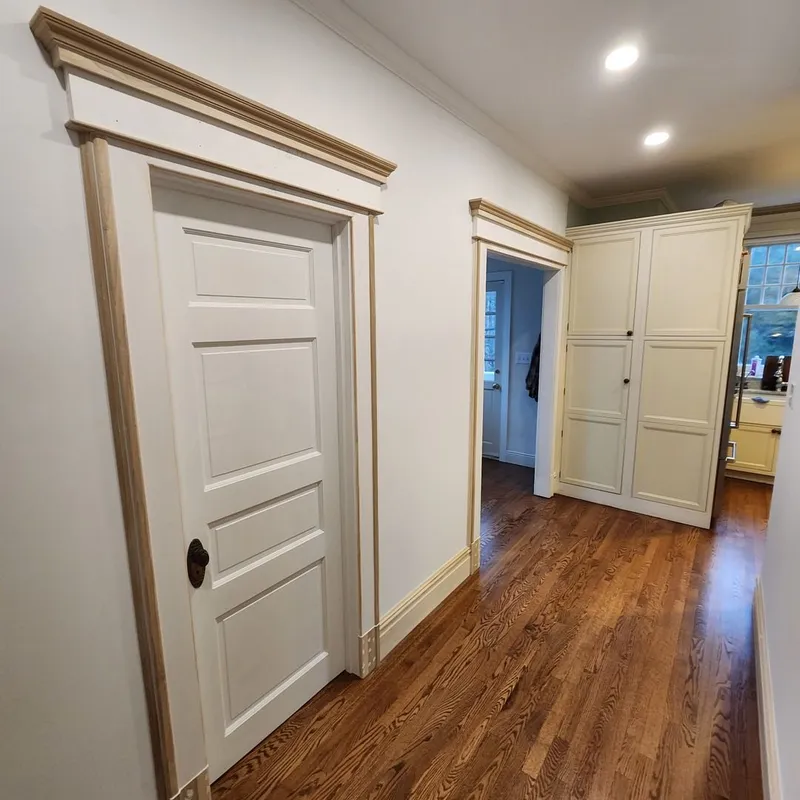 Hallway and kitchen of a 1910 home in Princeton, NJ, fully restored with custom trim after flood damage