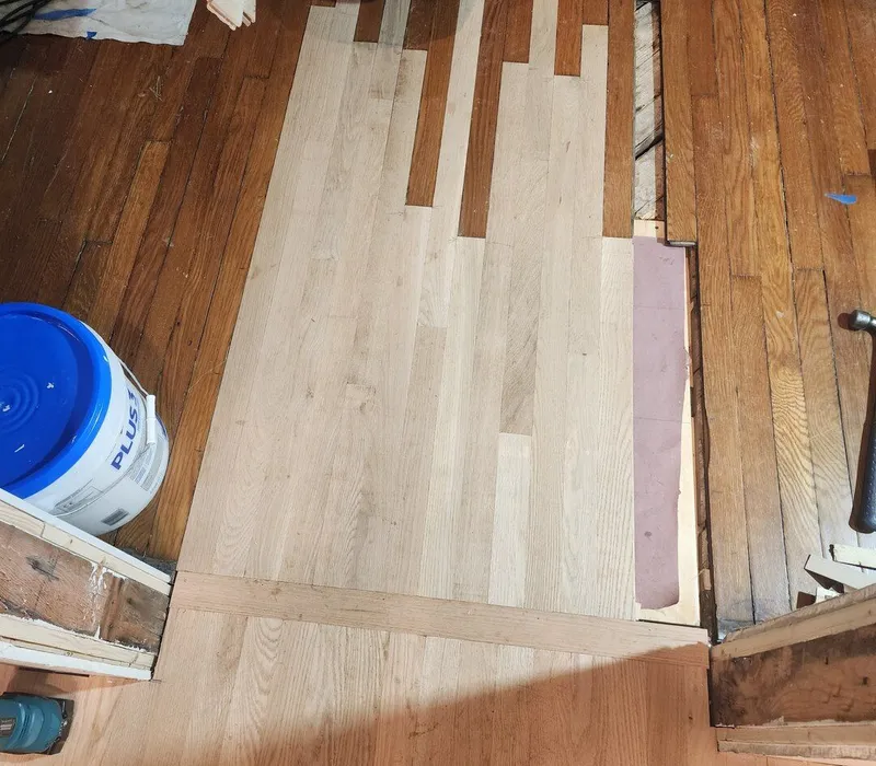 The weave of the new floorboards into the existing flooring almost complete.